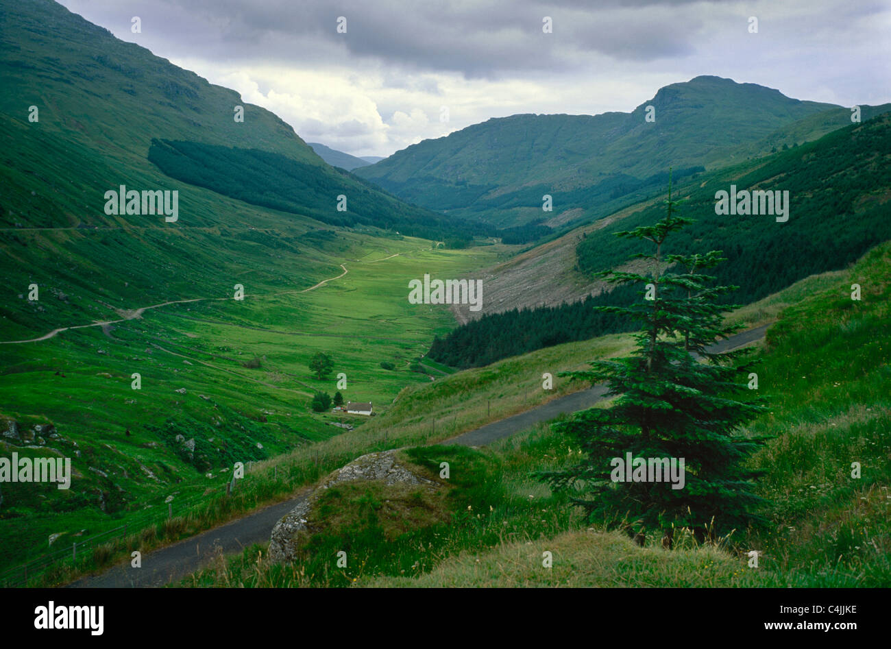 Scozia Regno Unito Highlands verde valle strade albero drammatiche nuvole attrazione turistica luogo storico paesaggio solitario Foto Stock