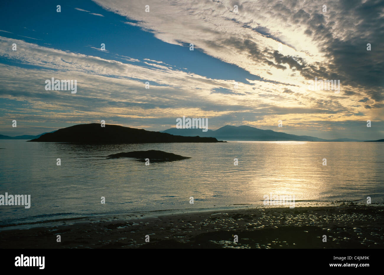 Scozia, Regno Unito, costa occidentale delle Highlands, il clima drammatico piccole isole che riflettono le nuvole del tramonto della spiaggia Foto Stock