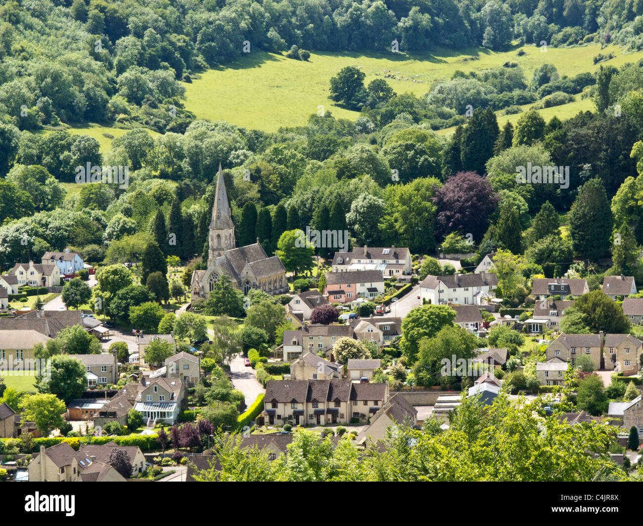 Vista guardando verso il basso sulla Woodchester la chiesa ed il villaggio vicino a Stroud, Gloucestershire, un grazioso villaggio in Cotswolds Foto Stock