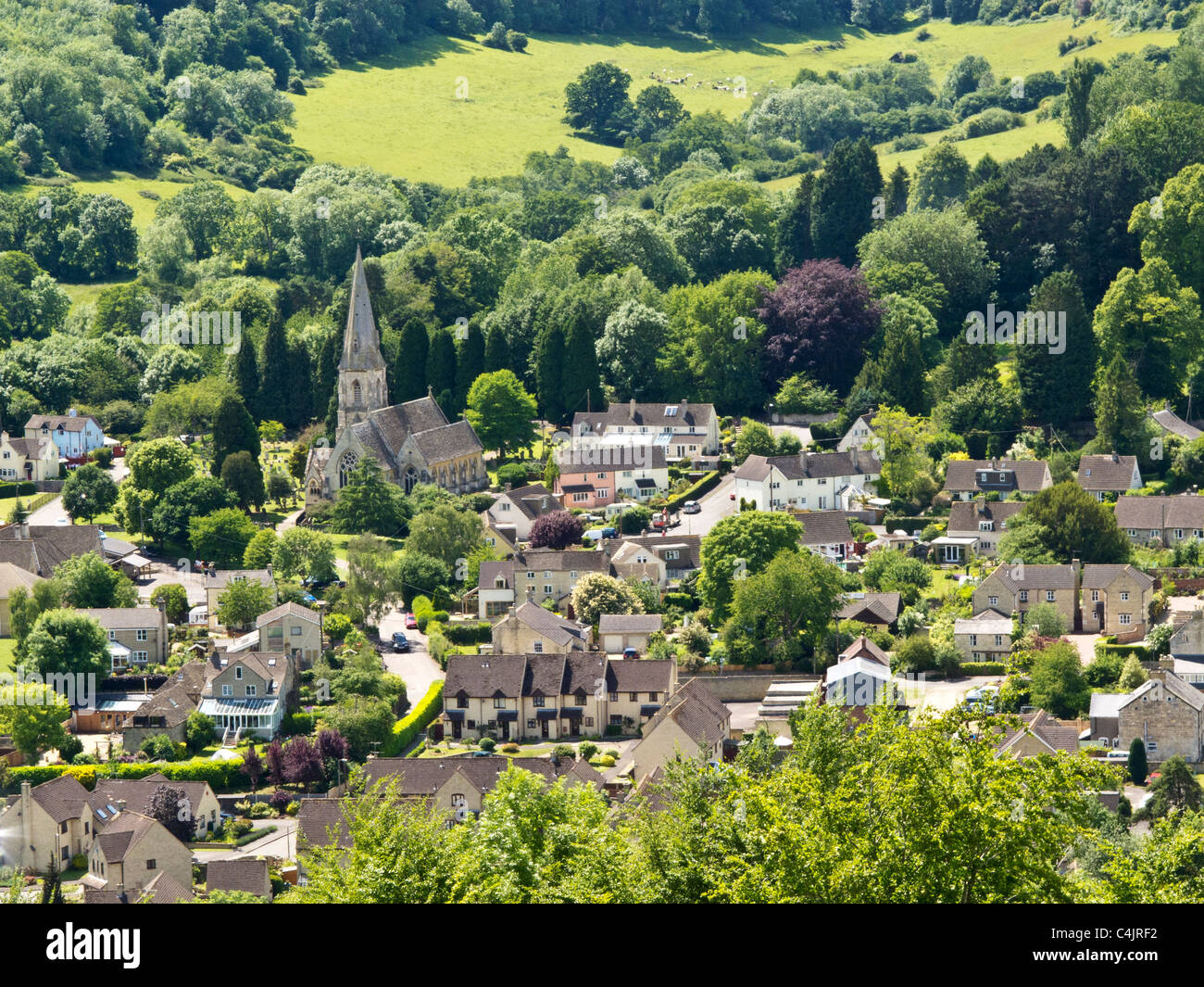 Vista guardando verso il basso sulla Woodchester la chiesa ed il villaggio vicino a Stroud, Gloucestershire, un grazioso villaggio in Cotswolds Foto Stock
