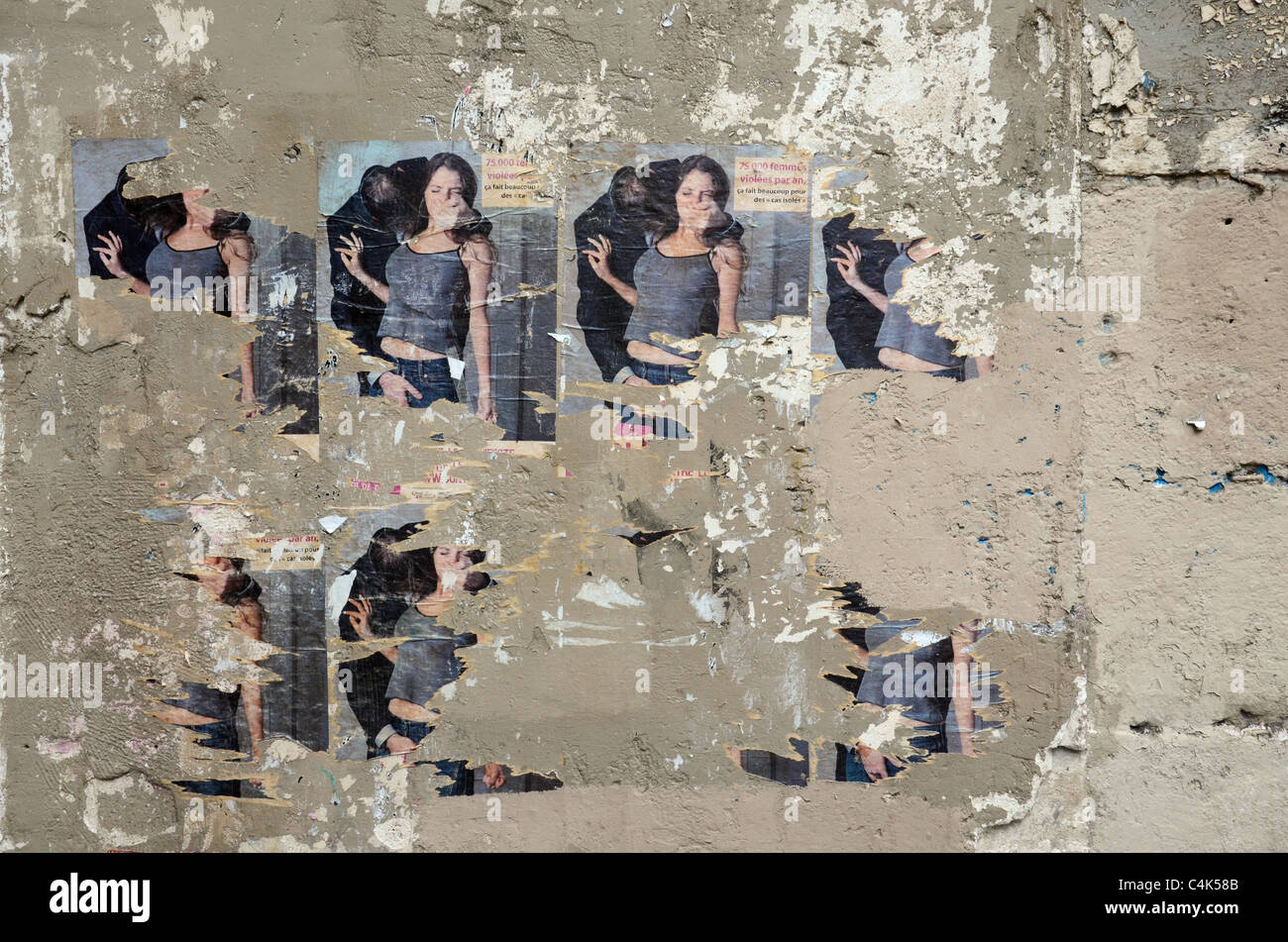 Manifesti stracciati evidenziando la violenza contro le donne in Rue Mouffetard nel Quartiere Latino di Parigi. Foto Stock