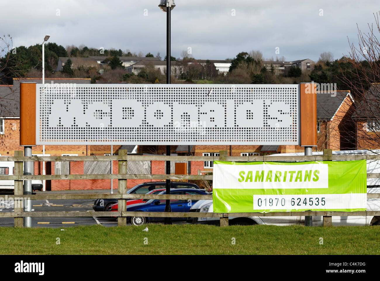 Indicazioni per McDonalds un ristorante fast food e i samaritani helpline adiacenti, Aberystwyth, Galles Foto Stock