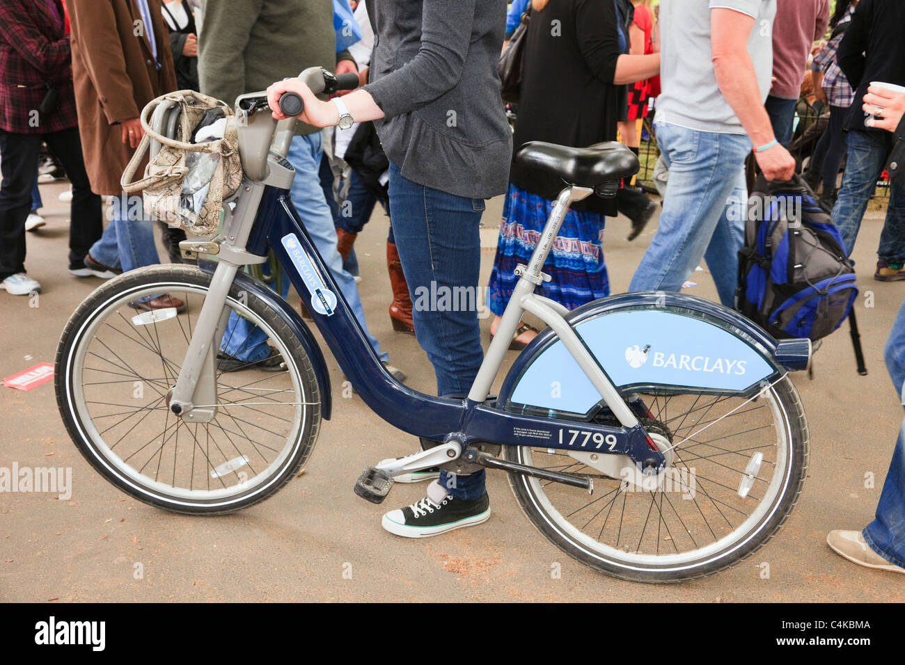 Persona spingendo un libero di condividere Barclays bike per le strade della città di Londra, Inghilterra, Regno Unito, Gran Bretagna. Foto Stock
