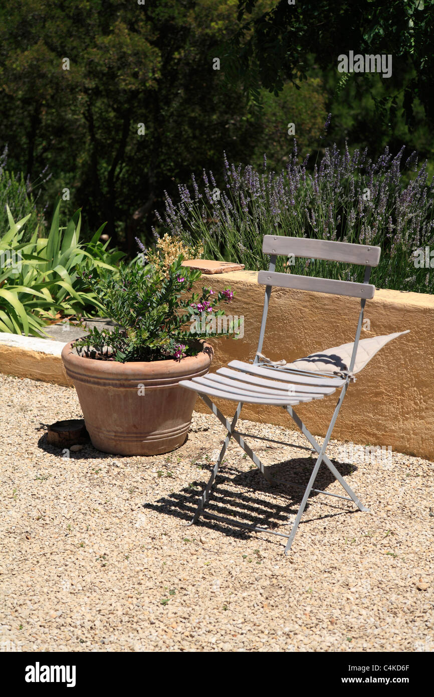 Tradizionale Francese giardino pieghevole sedia in giardino interno in Provenza Francia vento di Maestrale soffia cuscino giorno ventoso Foto Stock