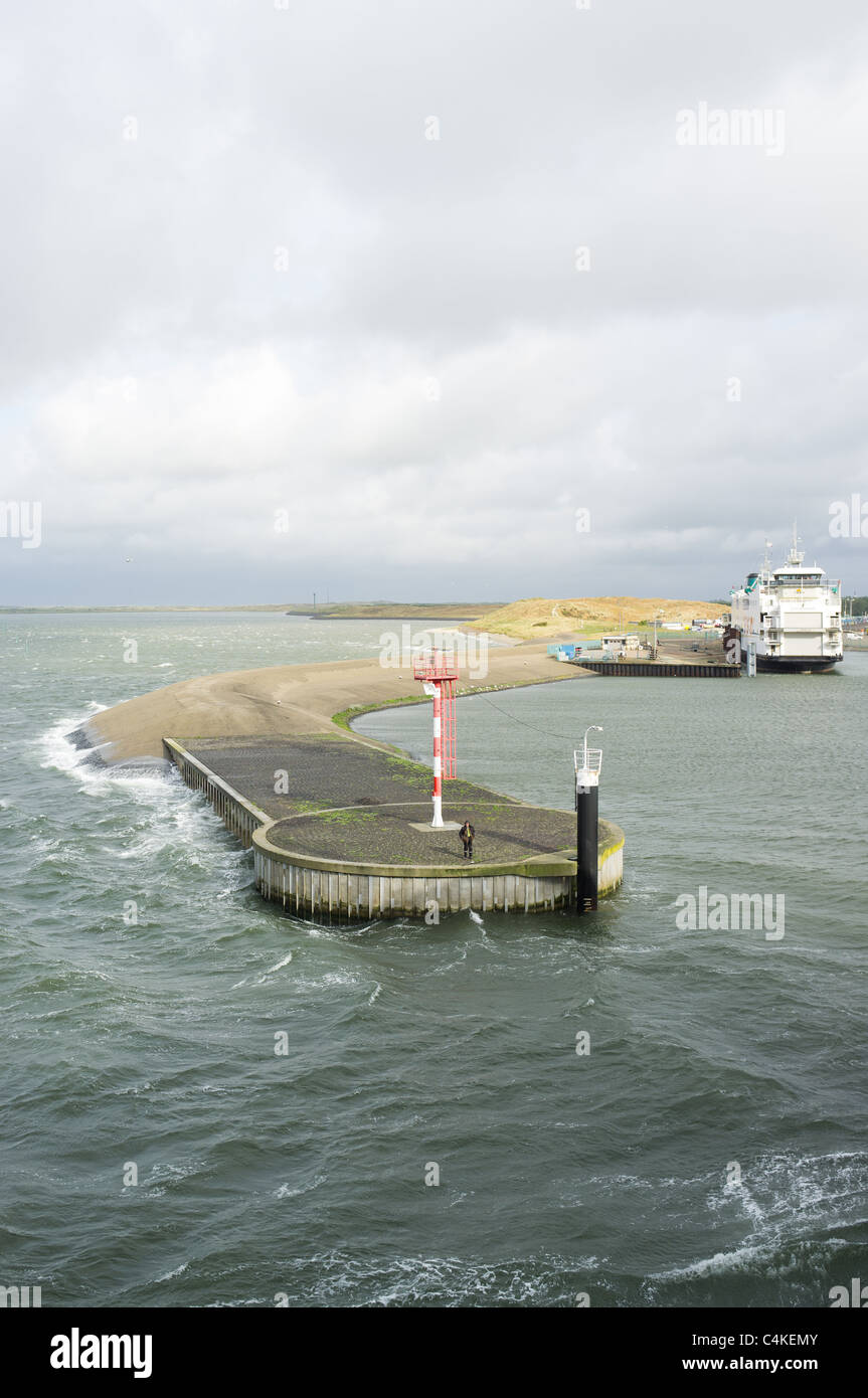 Parte del porto da cui partono i traghetti su Texel con un uomo in piedi e in attesa sul molo Foto Stock