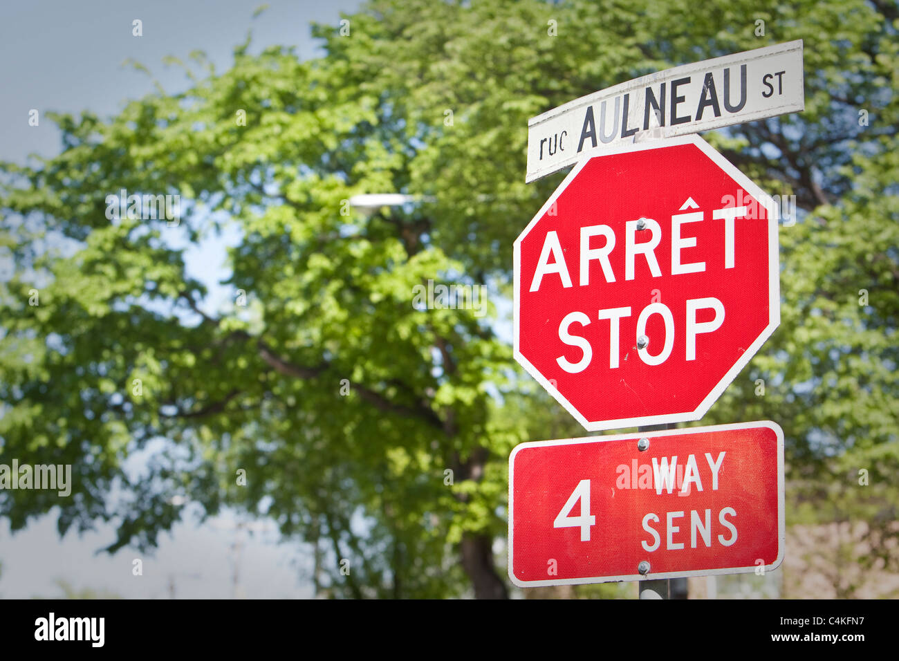 Un Francese-inglese bilingue segno di arresto viene visto su rue Aulneau Street nel quartiere di Winnipeg di Saint-Boniface Foto Stock