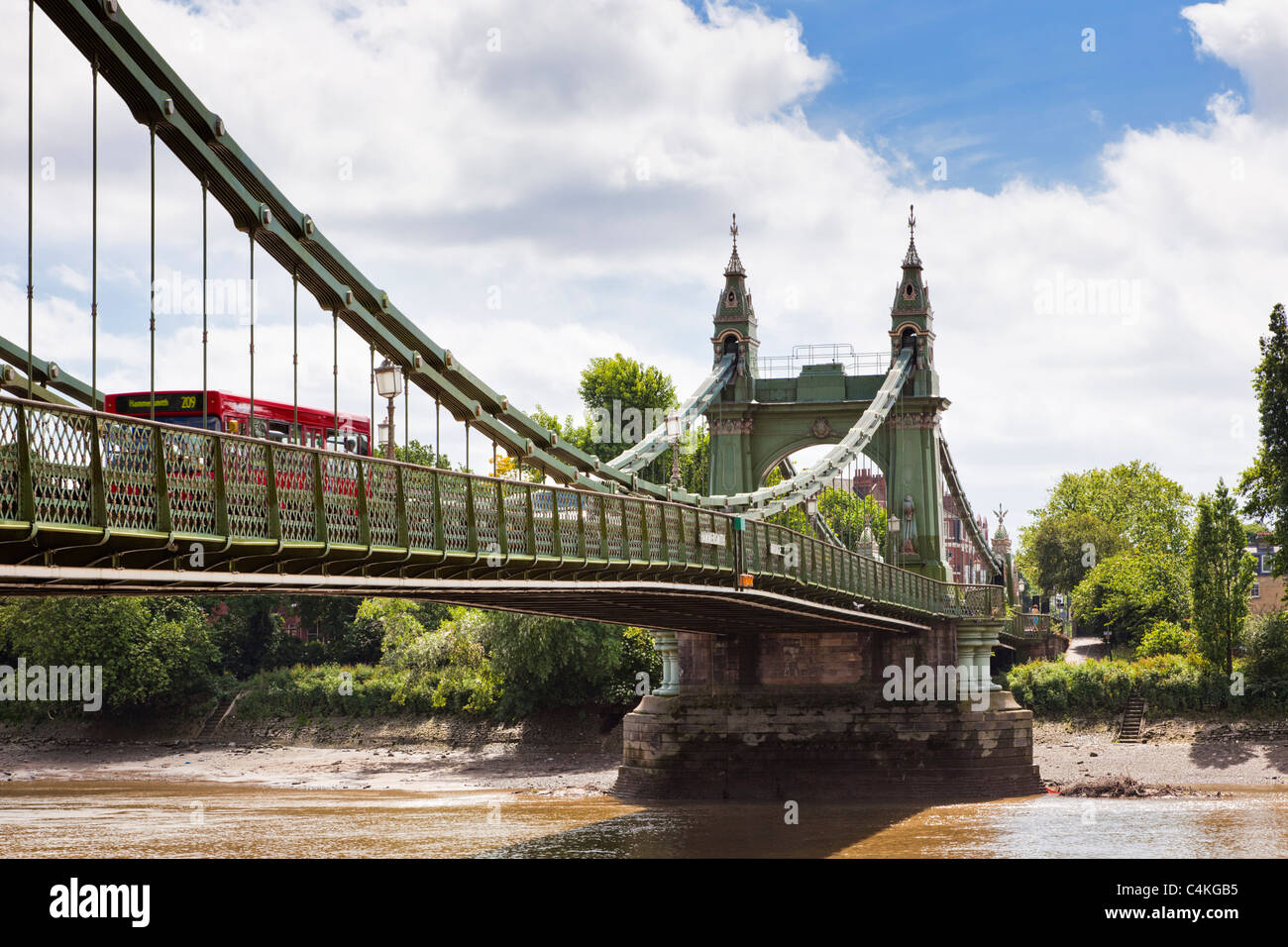 London Bus attraversando Hammersmith Bridge sul fiume Thames, London, England, Regno Unito Foto Stock