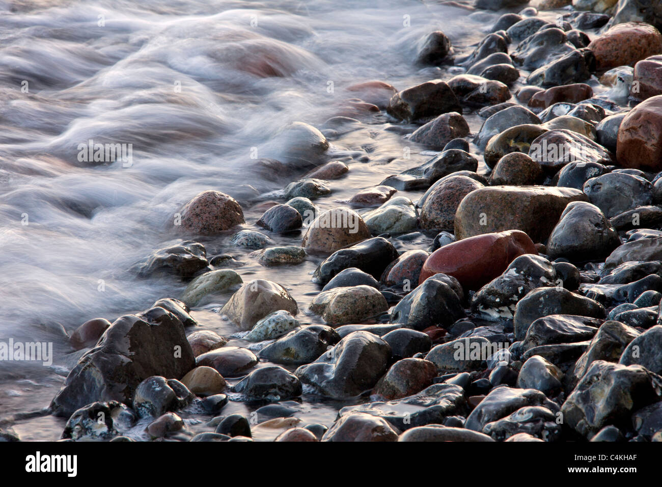 I ciottoli sulla spiaggia nel surf con la bassa marea, Germania Foto Stock