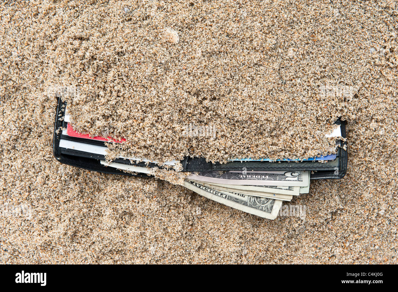 Un portafoglio perso in spiaggia con contanti e carte di credito Foto Stock