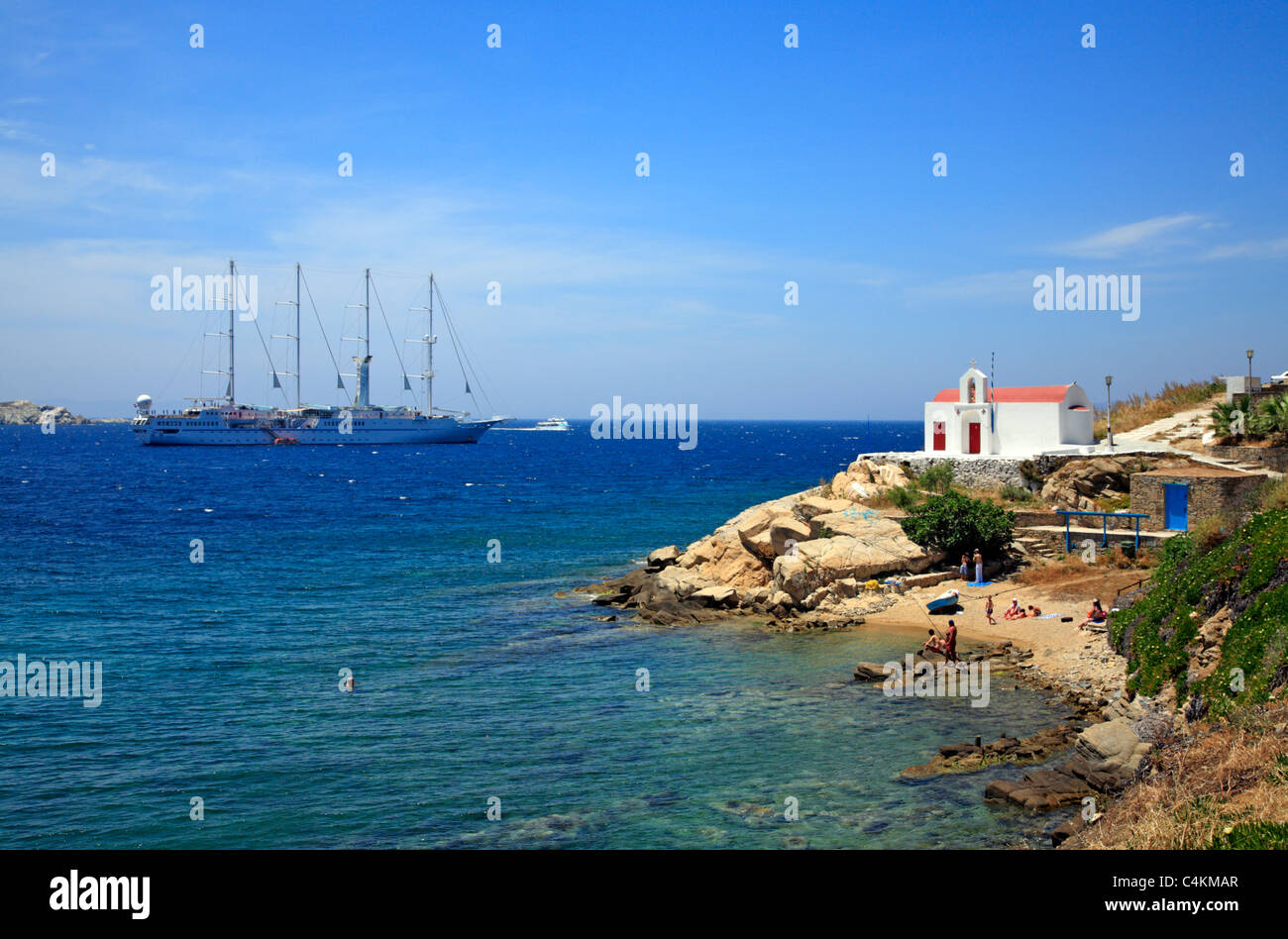 Chiesa sulla spiaggia e il vento dello Spirito nave a vela Mykonos Cicladi isola del Mar Egeo Grecia UE Unione europea EUROPA Foto Stock