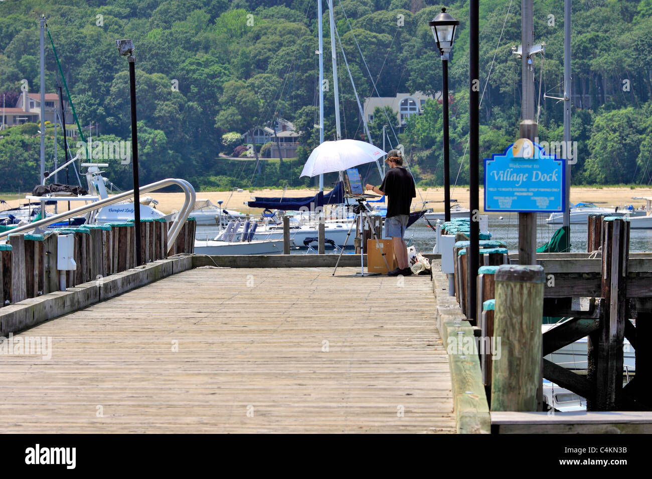 Plein Air artista pittura su dock del villaggio di Northport Long Island NY Foto Stock