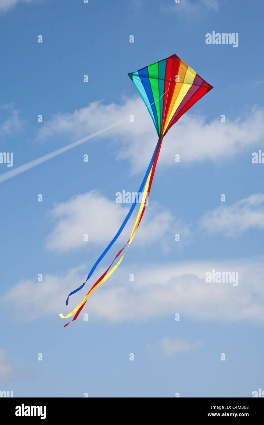 Rainbow kite battenti su una stringa con un blu cielo nuvoloso, Hampshire, Inghilterra, Regno Unito Foto Stock