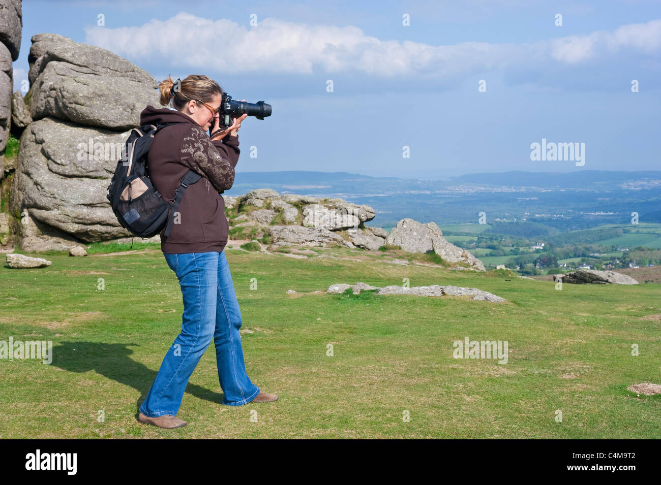 Un fotografo di scattare le foto della vista che circonda Haytor rocce nel Parco Nazionale di Dartmoor. Foto Stock