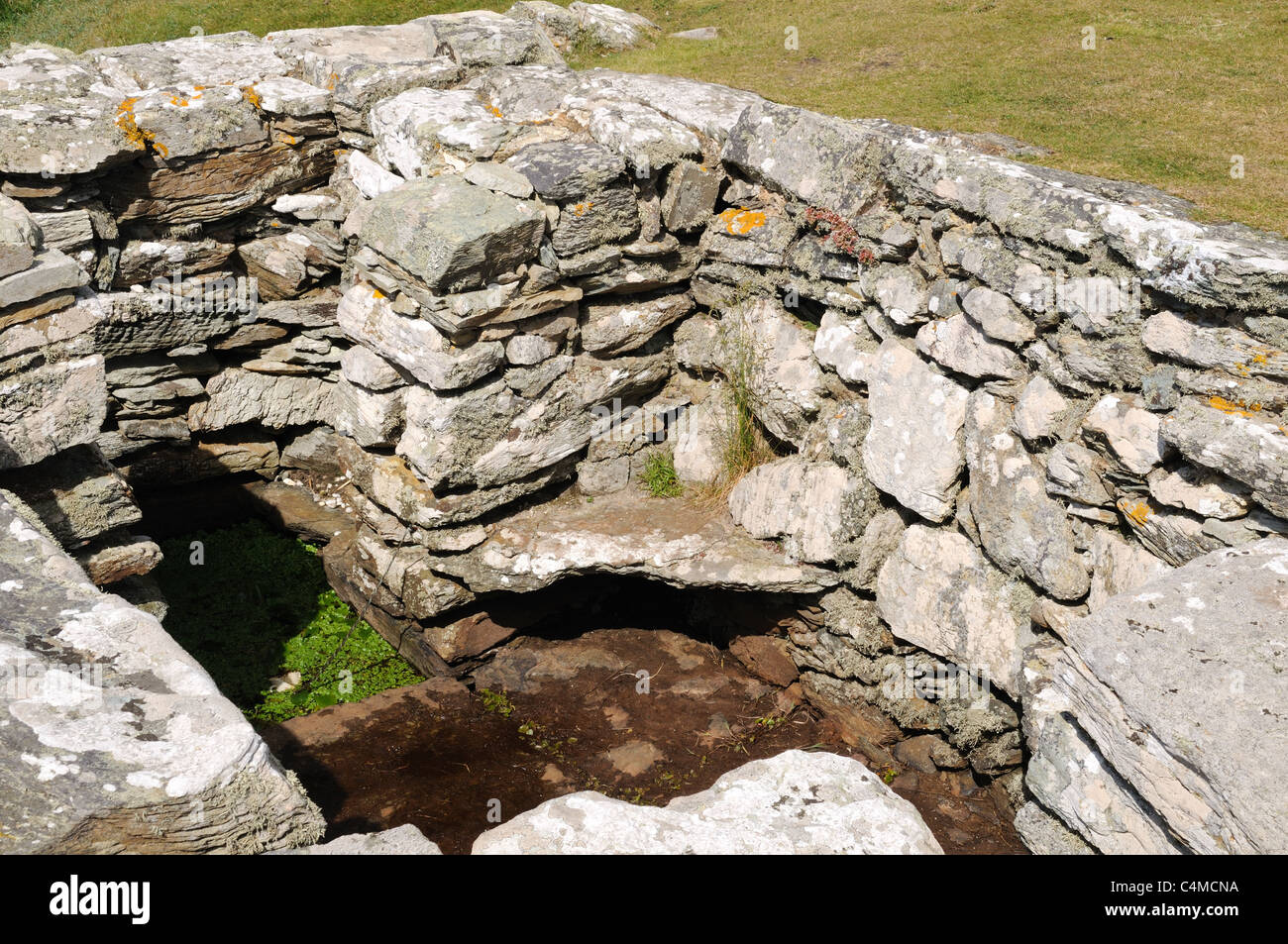 Il sedile in pietra sul lato St Gwenfaens Pozzo santo Rhoscolyn Anglesey Ynys Mon Gwynedd in Galles Cymru REGNO UNITO GB Foto Stock