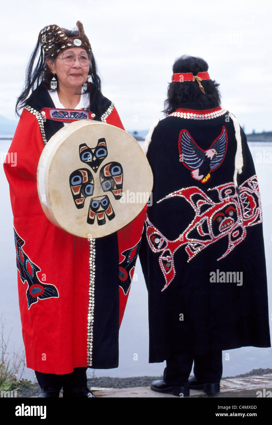 Due Tlingit Native American donne display tradizionale capes progettato con pulsanti e un tamburo della tribù Keex (kwaan) a Kake, Alaska, Stati Uniti d'America. Foto Stock