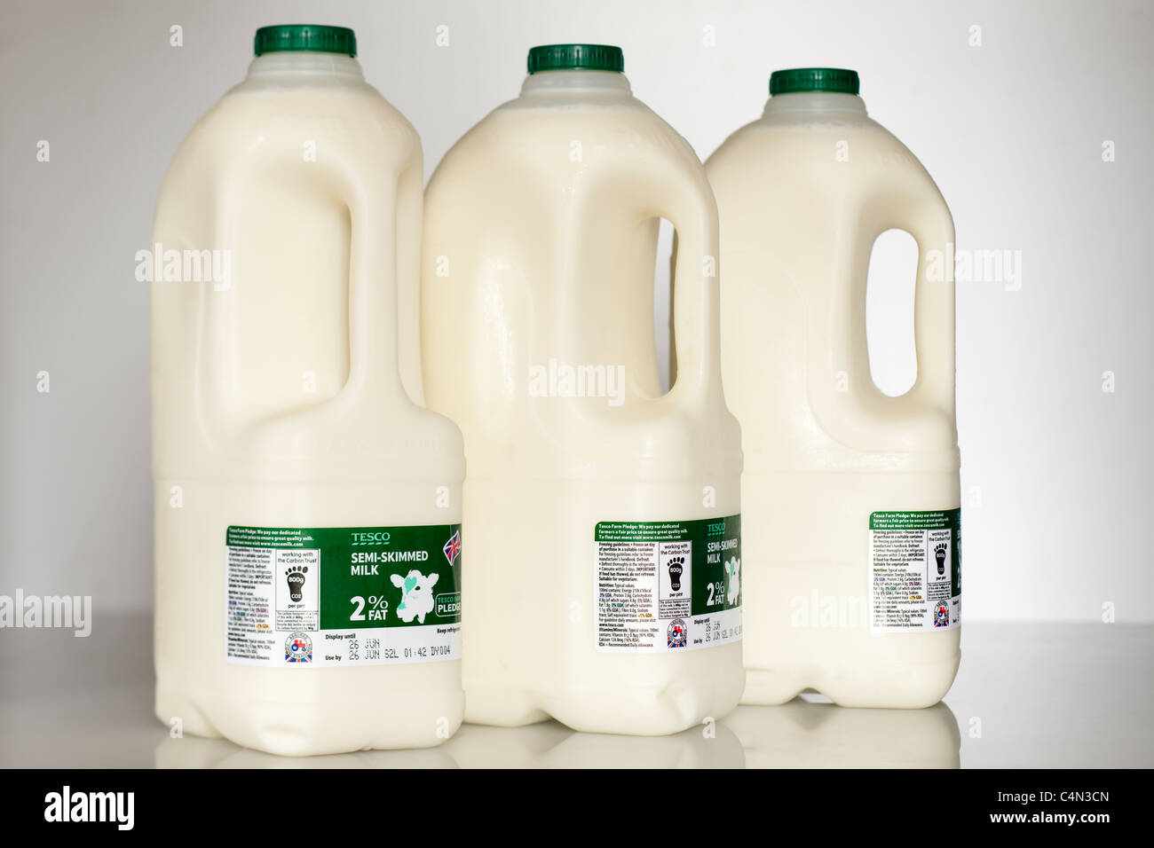 Tre e quattro in plastica pinta o litri 2.272 bottiglie di Tesco il latte parzialmente scremato Foto Stock