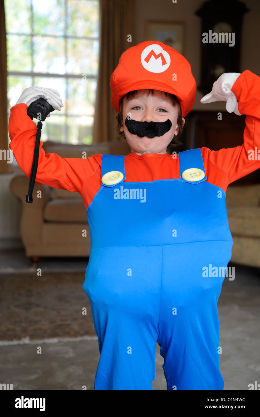 6 anno vecchio ragazzo giocando Mario Bros su un Wii vestito in un Mario fancy dress costume Foto Stock