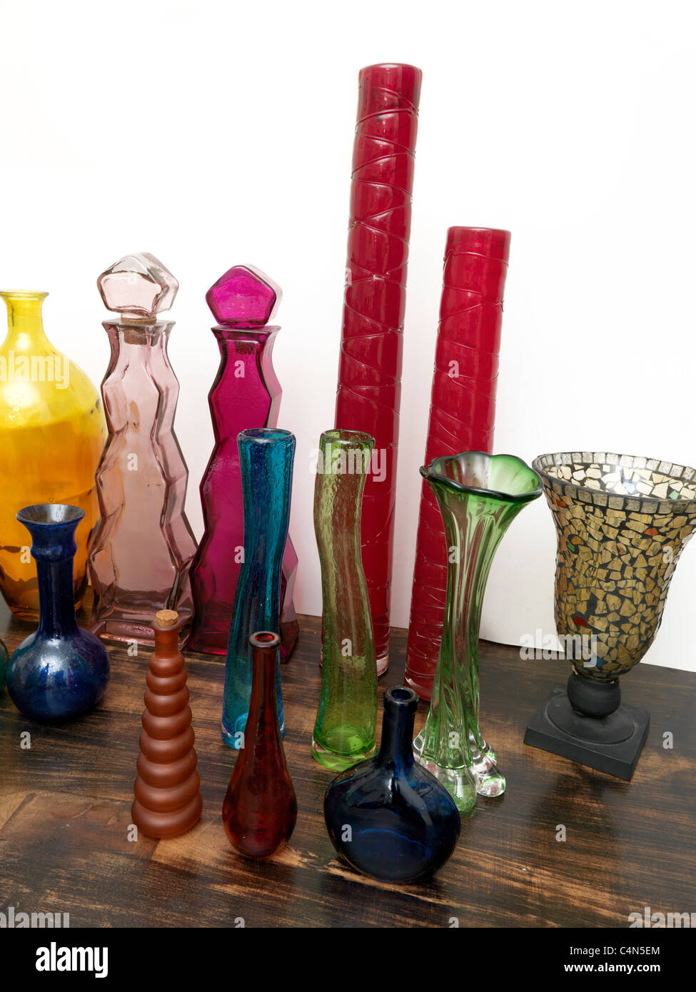 Una raccolta di diversi colori e forme di bottiglie e vasi da vetro riciclato Foto Stock