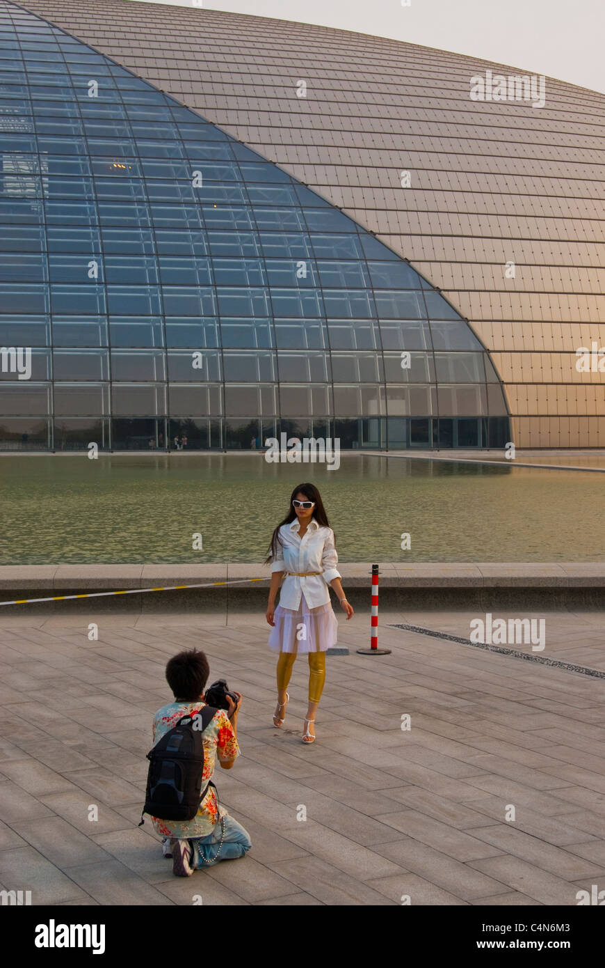 Pechino, Cina, fotografo che fotografa la donna, al di fuori del Grand National Theatre Building, (architetto di credito: Paul Andreu) Foto Stock