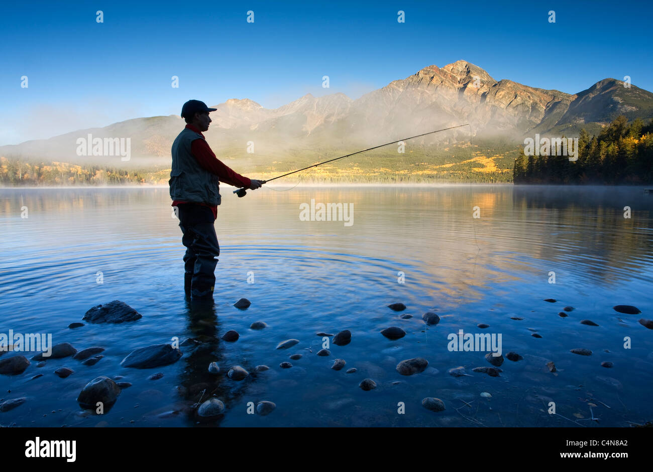 Metà maschio di età di Pesca a Mosca Report di Pesca in Lago Piramide, il Parco Nazionale di Jasper, Alberta, Canada. Foto Stock