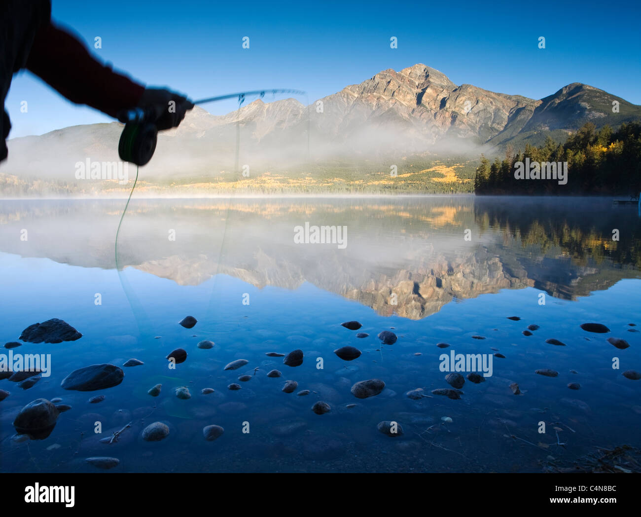 Close up casting fly canna da pesca all'alba, Lago Piramide, il Parco Nazionale di Jasper, Alberta, Canada. Foto Stock