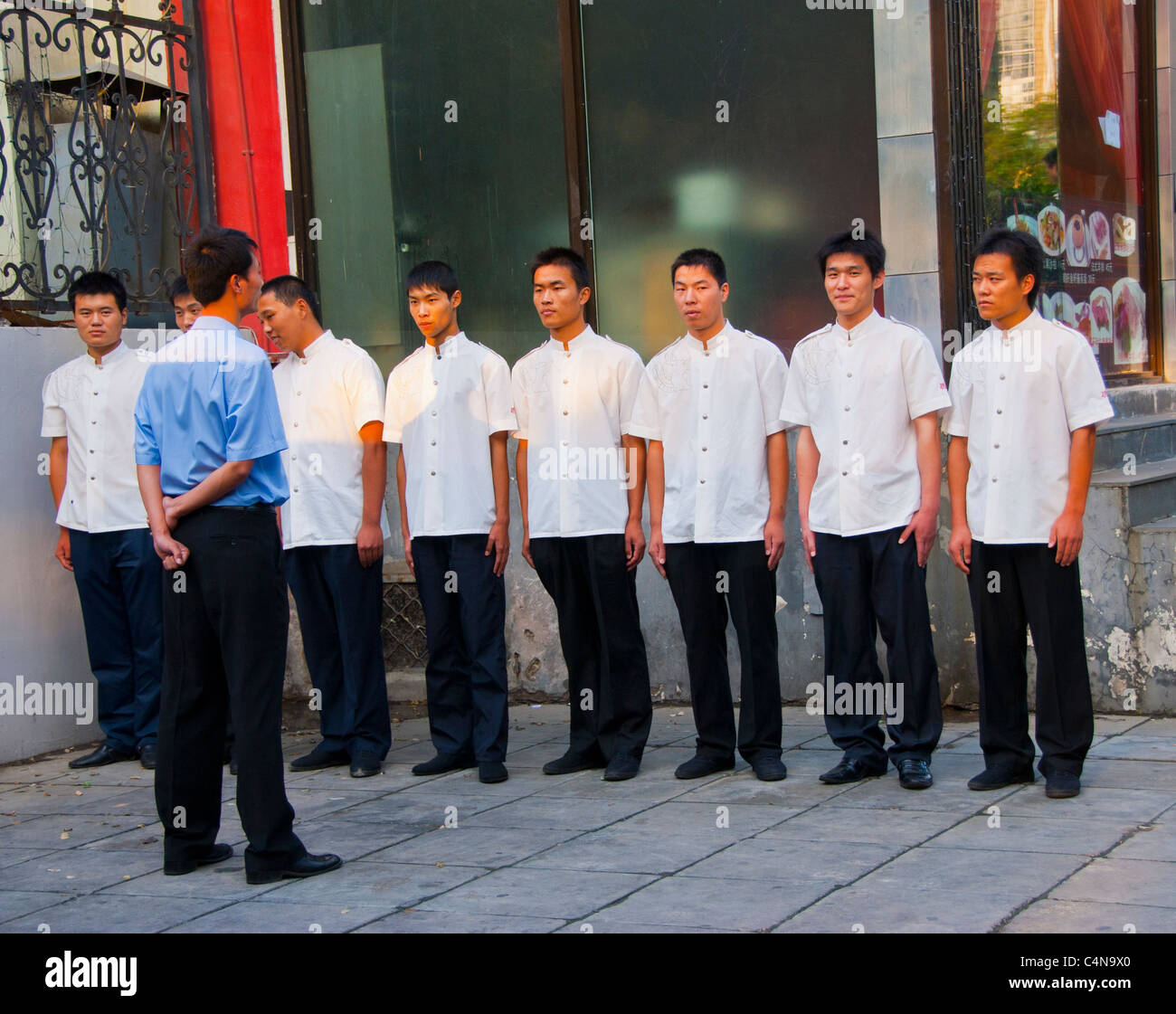 Pechino, Cina, Group Chinese Restaurant Workers, in piedi all'attenzione, schierati fuori, motivati dal loro manager, 'Guije Food Street » Front Foto Stock