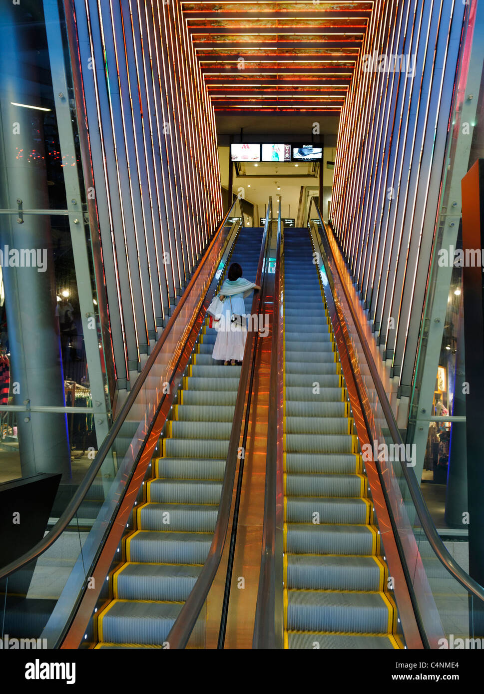 Donna su ingresso escalator per Orchard Central shopping mall, Orchard Road, Singapore. Foto Stock