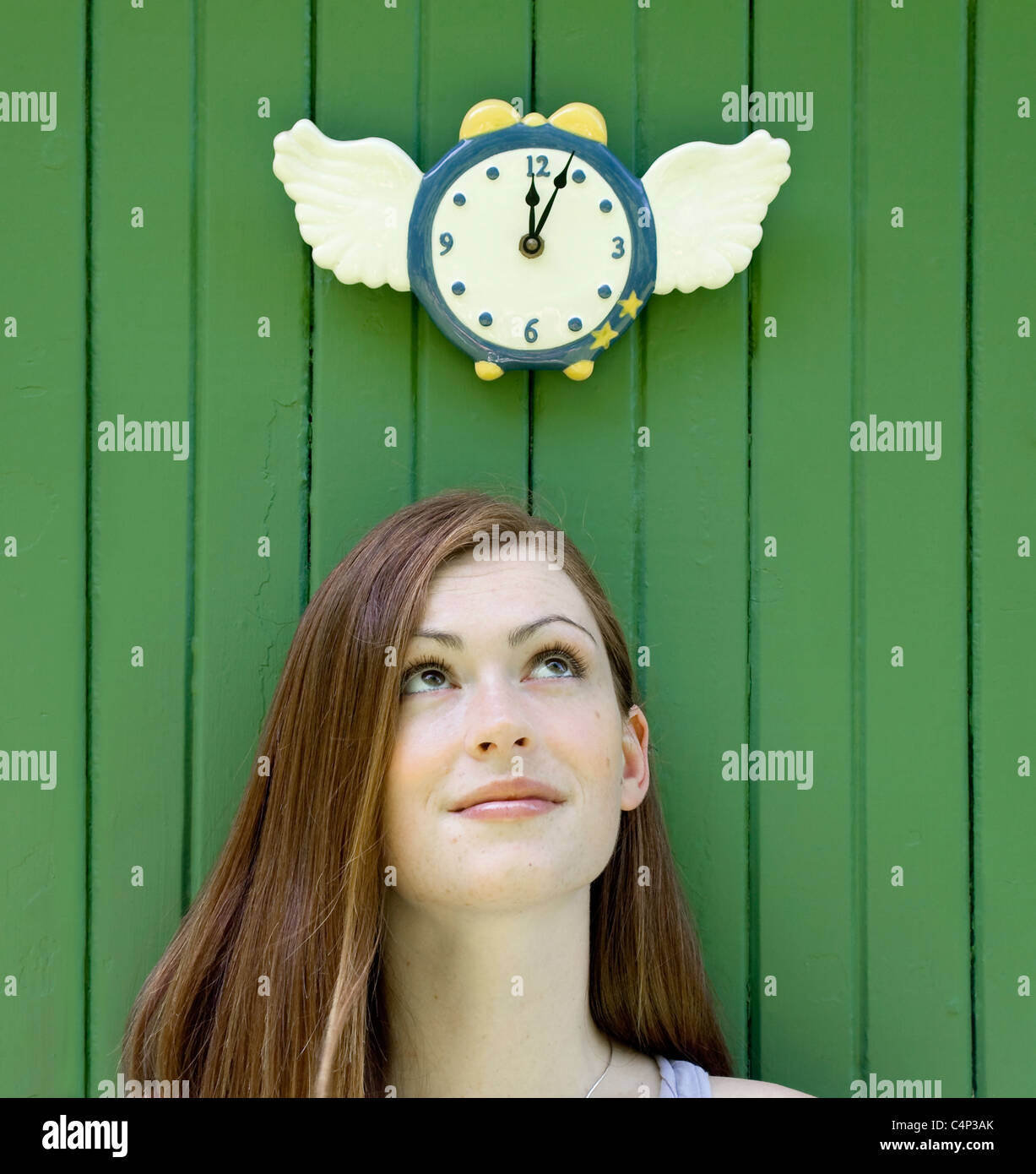 Giovane donna alla ricerca fino a un orologio alato (il tempo vola),  Ontario, Canada Foto stock - Alamy