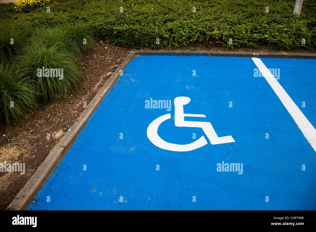 Sedia a rotelle il simbolo di parcheggio sul marciapiede Foto Stock