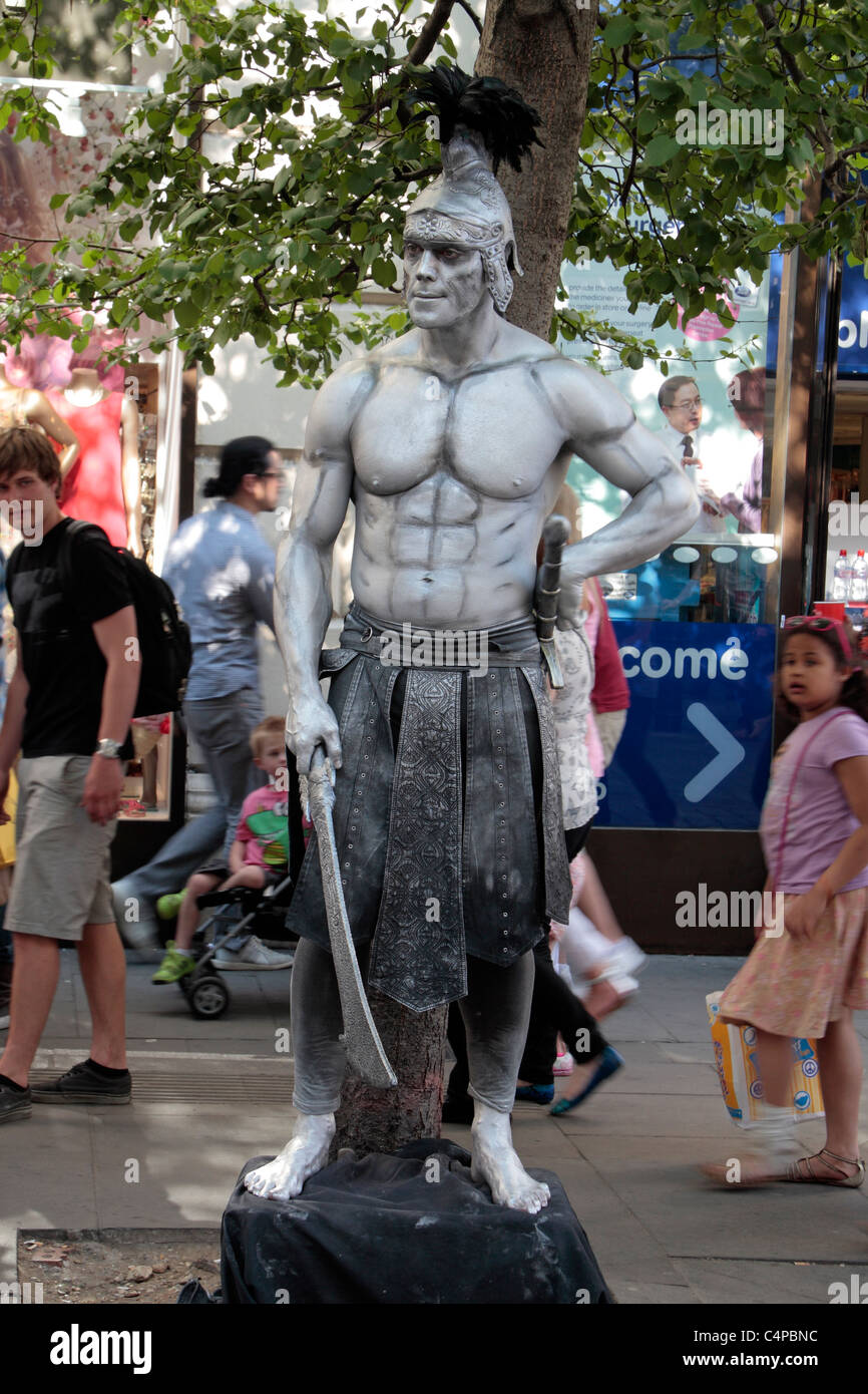 Un animatore di strada, vestito come un pauroso centurione romano in Covent Garden di Londra, Regno Unito. Foto Stock