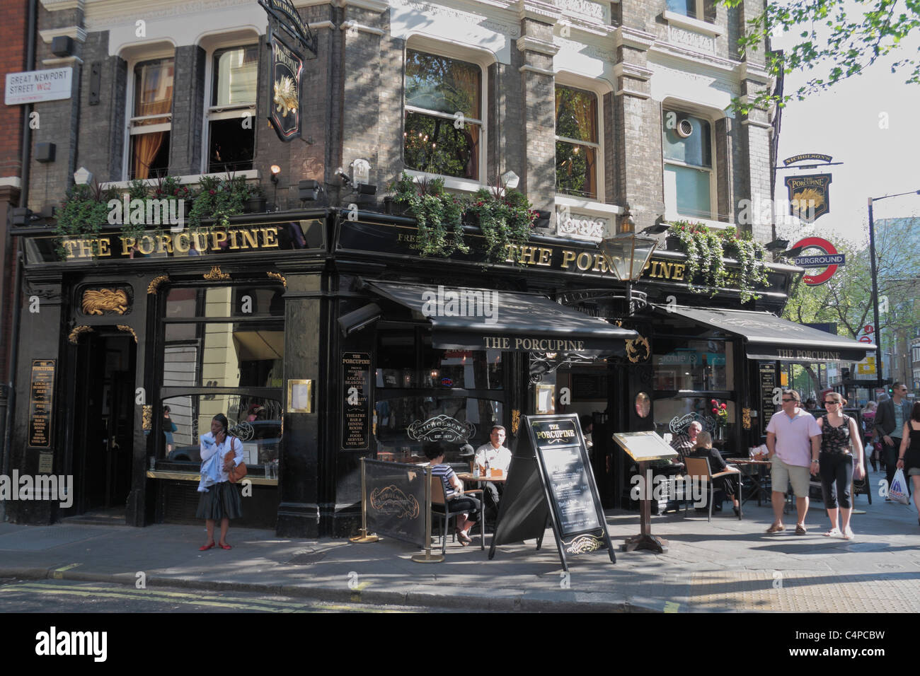 Le persone hanno un drink pomeridiano al di fuori dell'Istrice public house di Charing Cross Road, Covent Garden di Londra, Regno Unito. Foto Stock