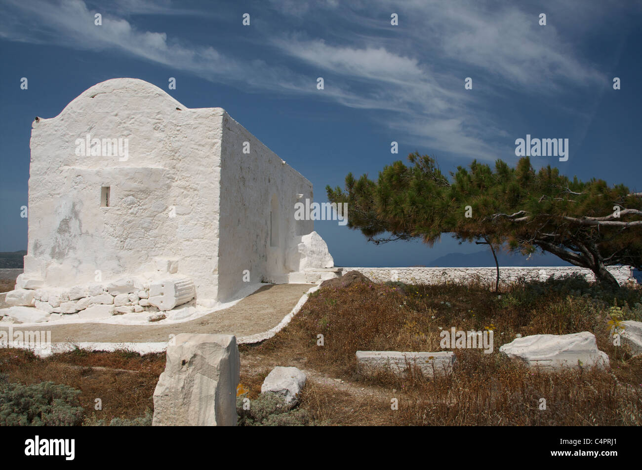 Alterati dal tempo, cappella dipinta di bianco e vento Albero scolpito sull'isola cicladica di Milos Foto Stock
