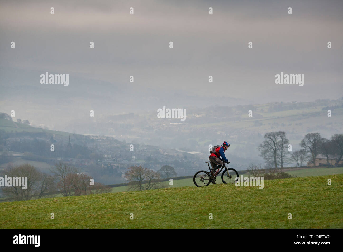 Mountain Biker cavalca un sentiero sterrato nel Regno Unito Foto Stock
