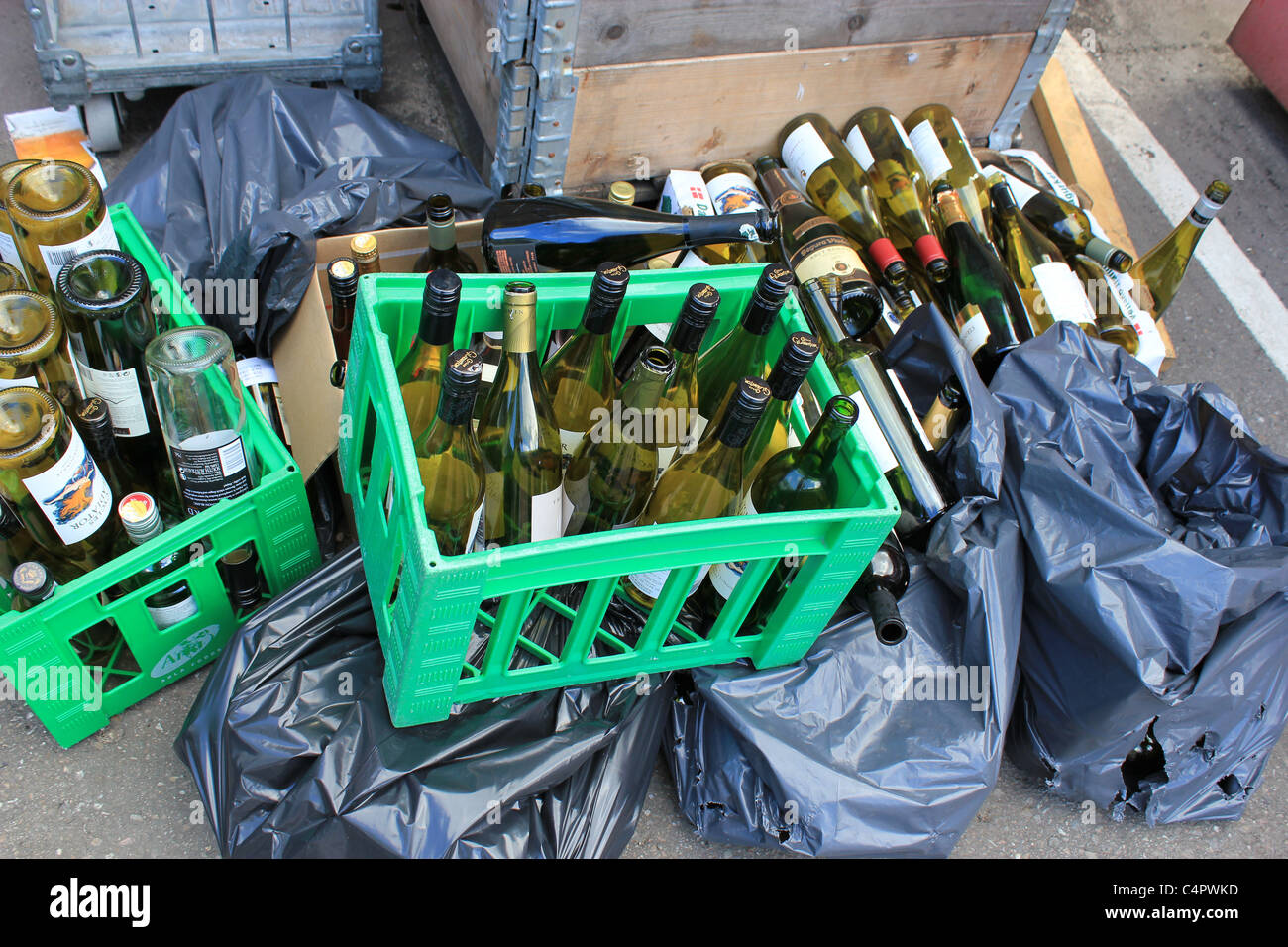 Svuotare le bottiglie di vino che stanno andando per il riciclaggio Foto Stock