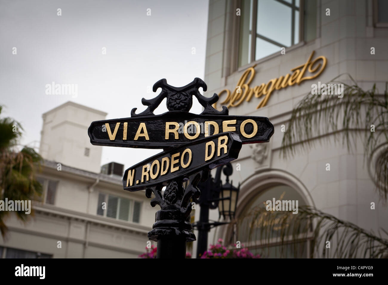 Un segno in corrispondenza dell'intersezione di Rodeo Drive e Via Rodeo con l'Archivio Breguet in background Foto Stock