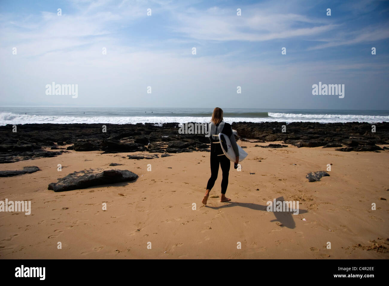 Surfer camminando verso l'oceano, Jeffreys Bay, Sud Africa Foto Stock