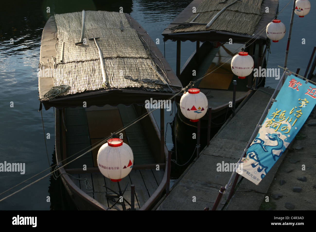 Barche di legno dal tetto ormeggiate sul lato del fiume vicino a Uji, Giappone. Foto Stock
