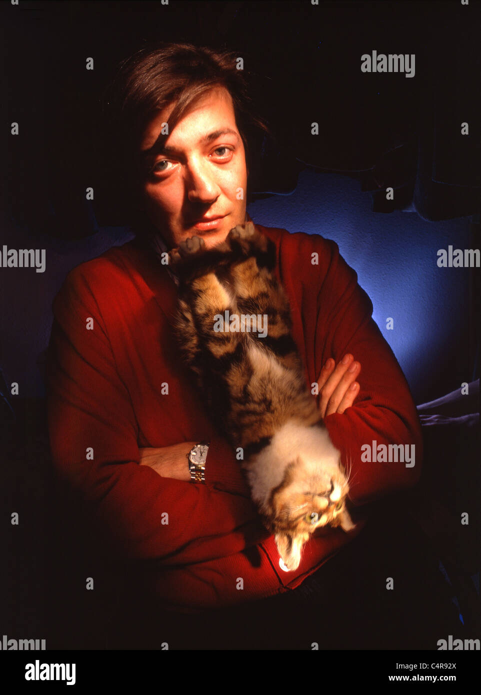 Ritratto di autore comico, emittente e celebrity Stephen Fry con gatto ripiene Foto Stock