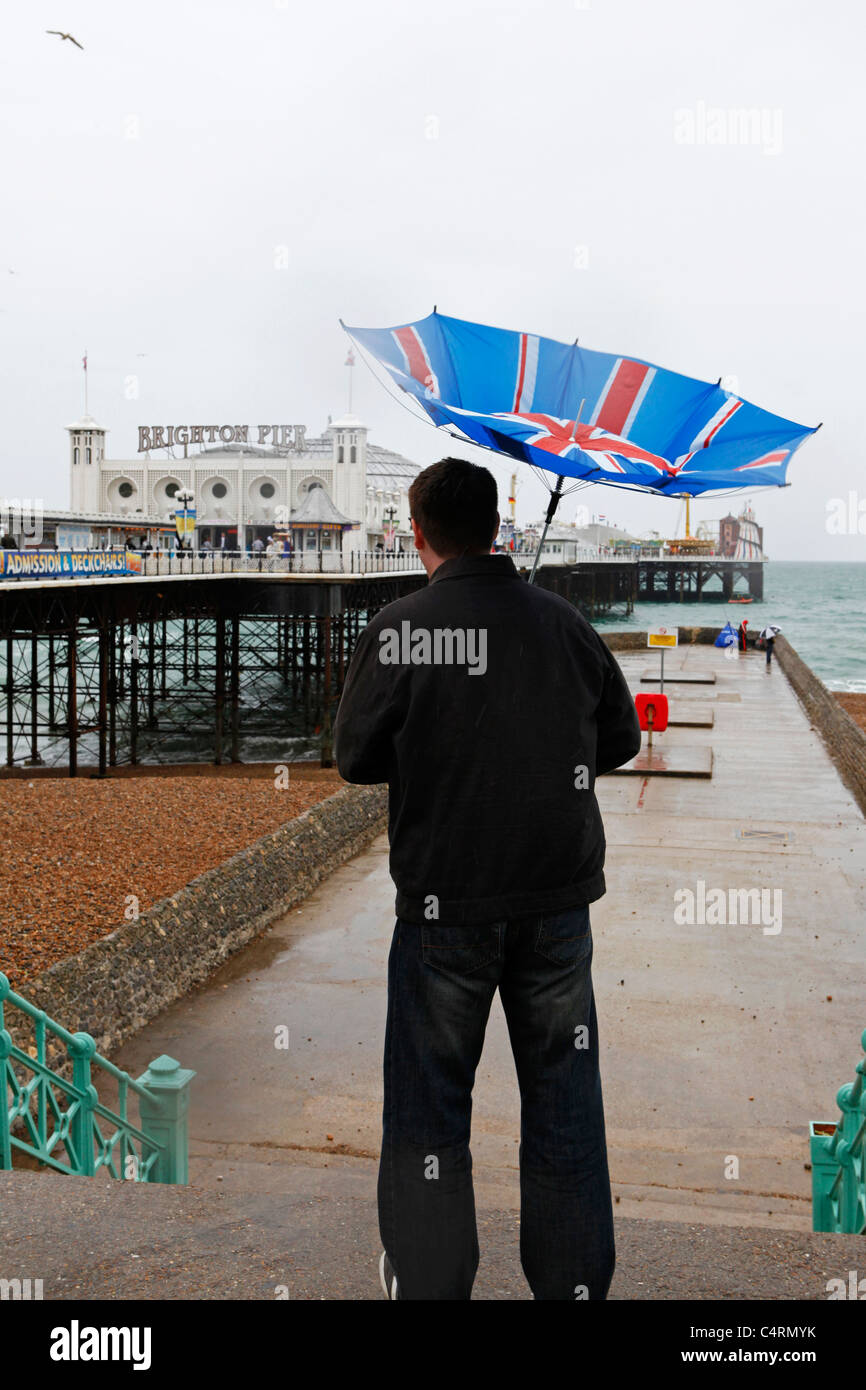 Regno Unito, London, Mayfair, pedonale con una Unione Jack ombrello  guardando un annuncio di Louis Vuitton con Foto stock - Alamy