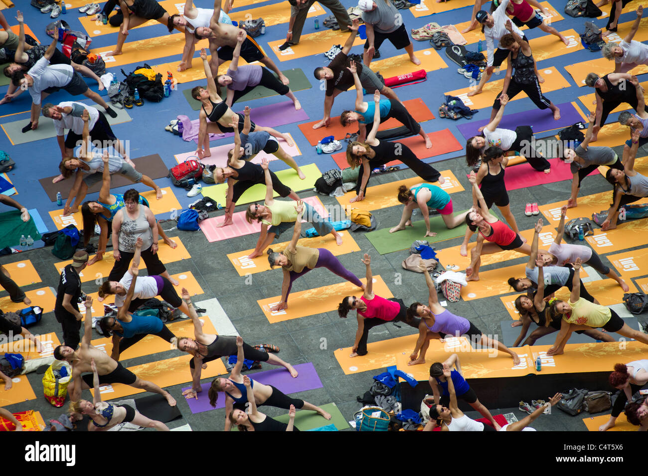 Migliaia di praticanti di yoga in Times Square a New York partecipano in un gruppo yoga classe osservando il Solstizio d'estate Foto Stock