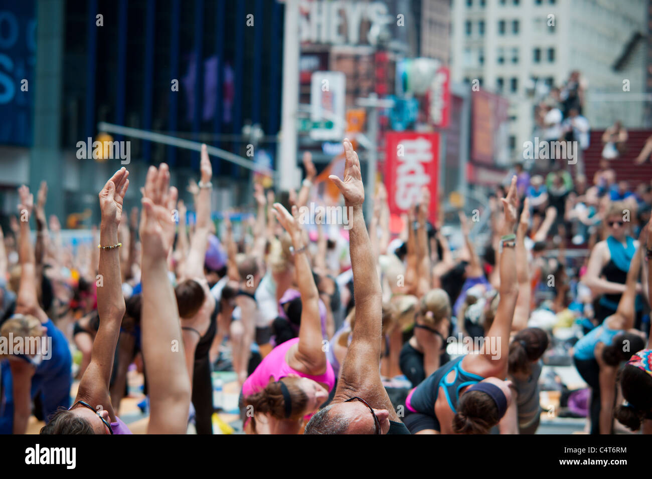 Migliaia di praticanti di yoga in Times Square a New York partecipano in un gruppo yoga classe osservando il Solstizio d'estate Foto Stock