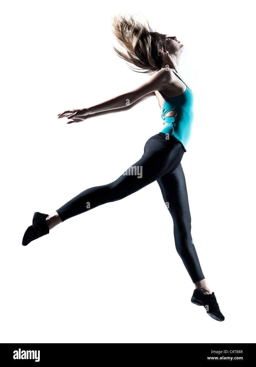 Vista laterale di una sportiva giovane donna jumping isolati su sfondo bianco Foto Stock