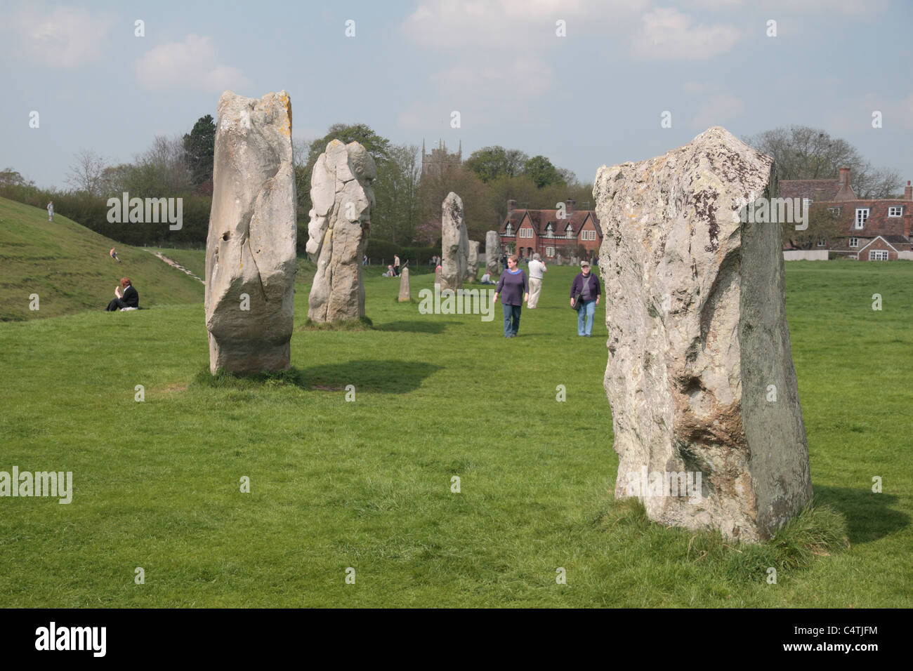 I visitatori a camminare accanto al cerchio esterno di Avebury Henge & circoli di pietra sito, Wiltshire, Inghilterra. Foto Stock