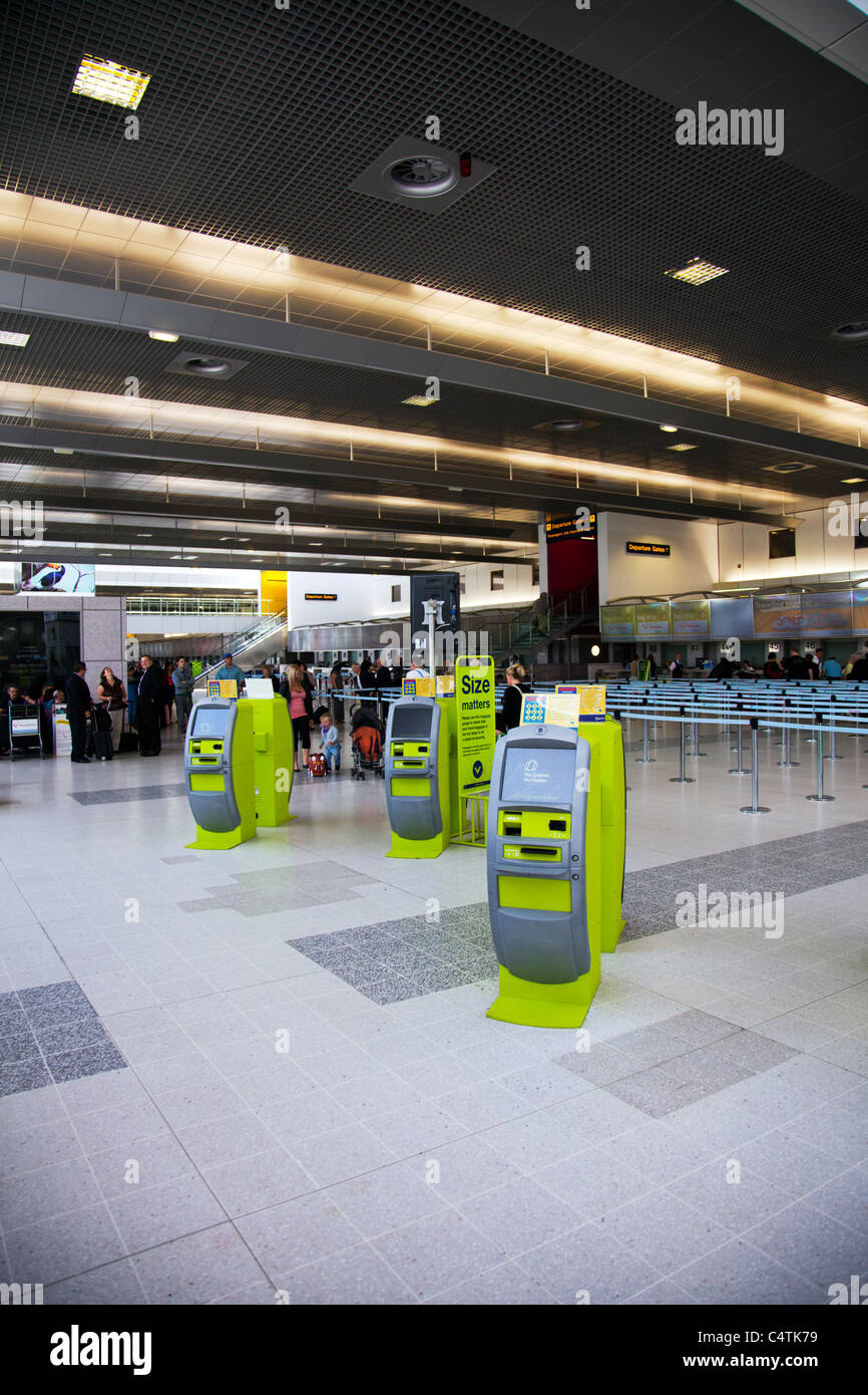 Il terminale 2, Aeroporto di Manchester, Inghilterra, vacanze Valigia controllo automatico in macchine green free standing Foto Stock