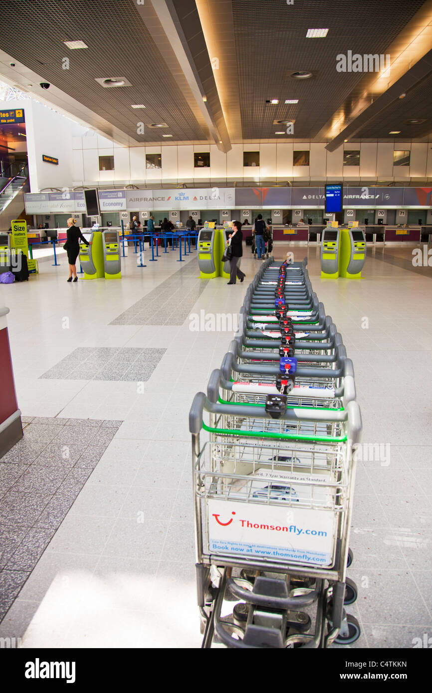 Il terminale 2, Aeroporto di Manchester, Inghilterra, vacanze valigia trolley linea thomson travel annuncio Foto Stock