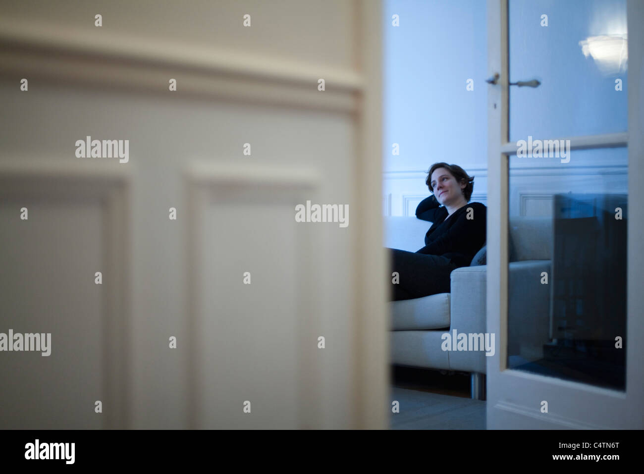 Donna rilassante sul divano Foto Stock