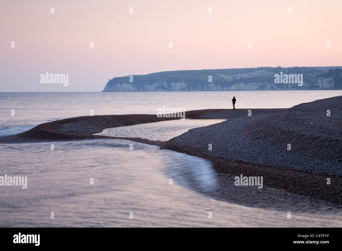La pesca al tramonto sulla spiaggia Seaton. Devon. In Inghilterra. Regno Unito. Foto Stock