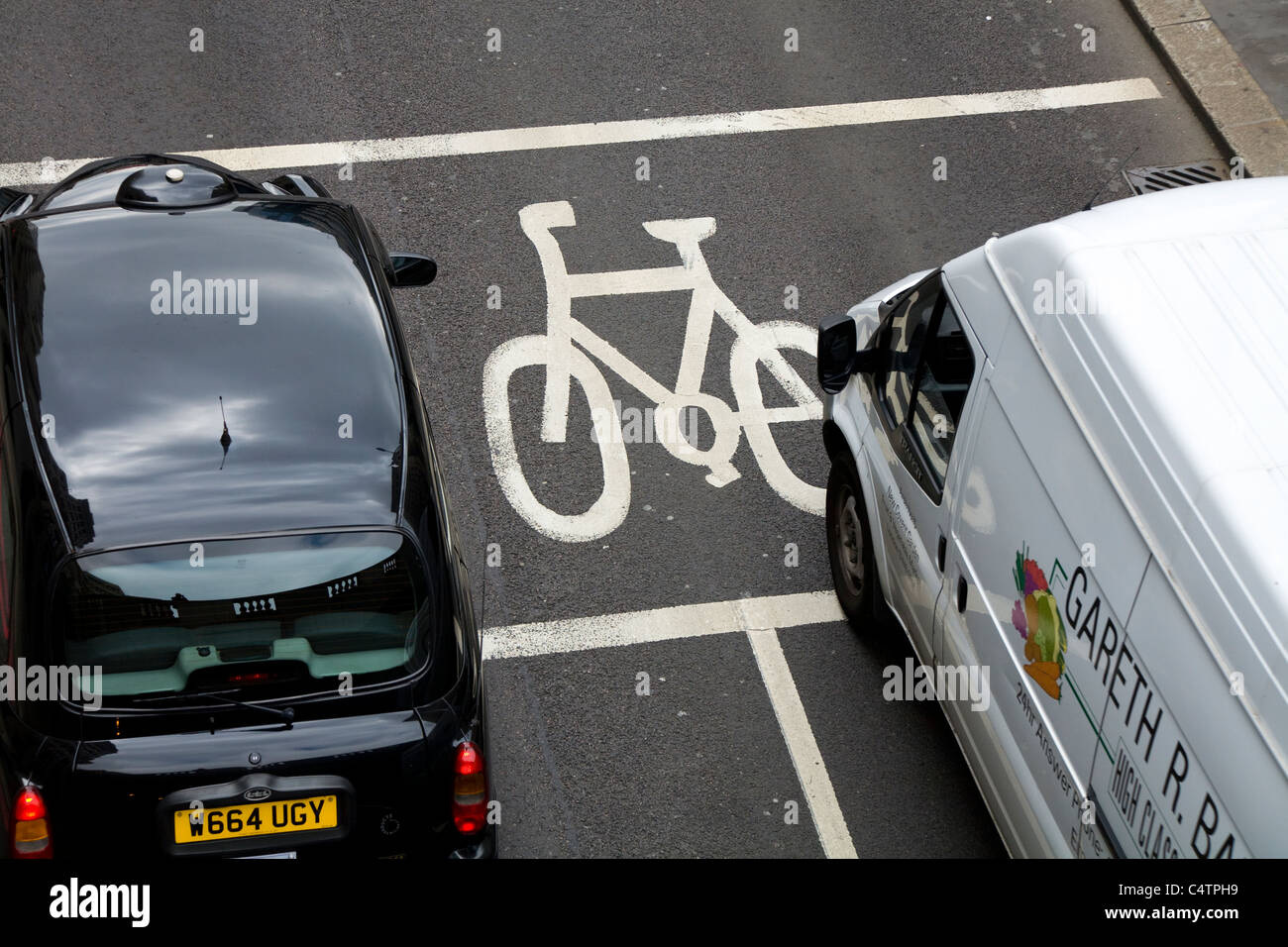 Arresto avanzata area linea (ASL) designato per ciclisti / dipinte di giunzione scatola per bici / moto / / ciclo corsie / lane. Londra. Un veicolo auto Black Cab taxi è nella casella Foto Stock