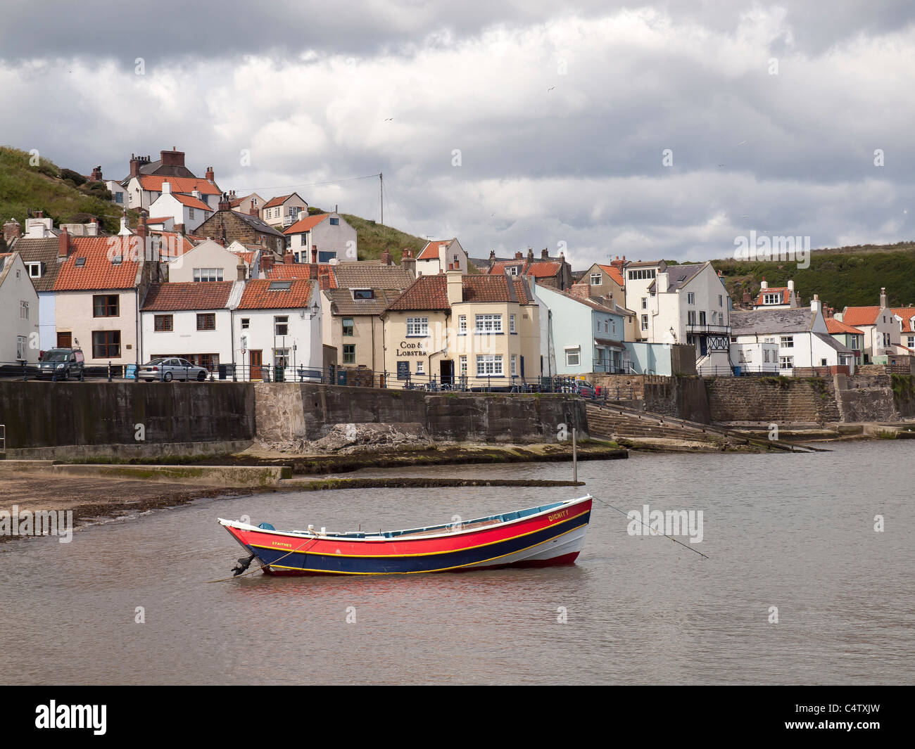 Tradizionali dello Yorkshire Coble barca da pesca nel porto di Staithes North Yorkshire Foto Stock