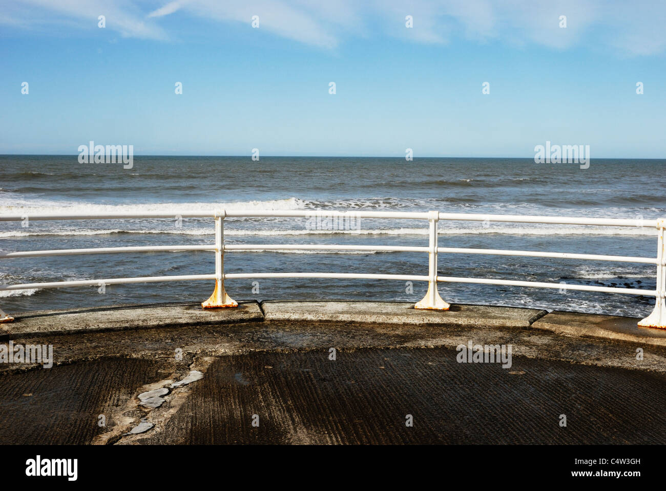 Ringhiere in bianco e cemento incrinato, Aberystwyth promenade, Galles Foto Stock